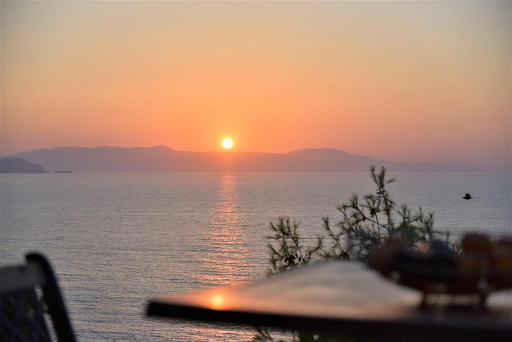 einen Sonnenuntergang über dem Wasser mit der Sonne am Himmel in der Unterkunft Emerald Apartment Halepa in Chania