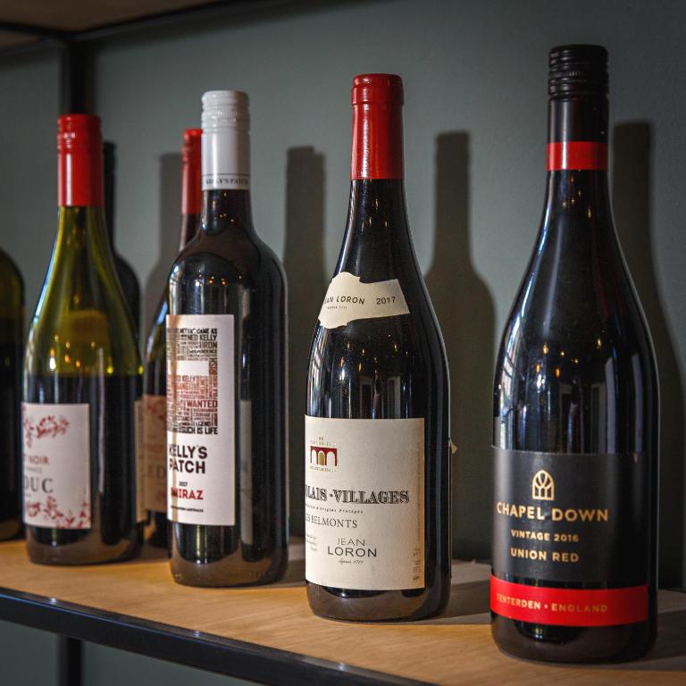 four bottles of wine sitting on a shelf at Blakeney House in Blakeney