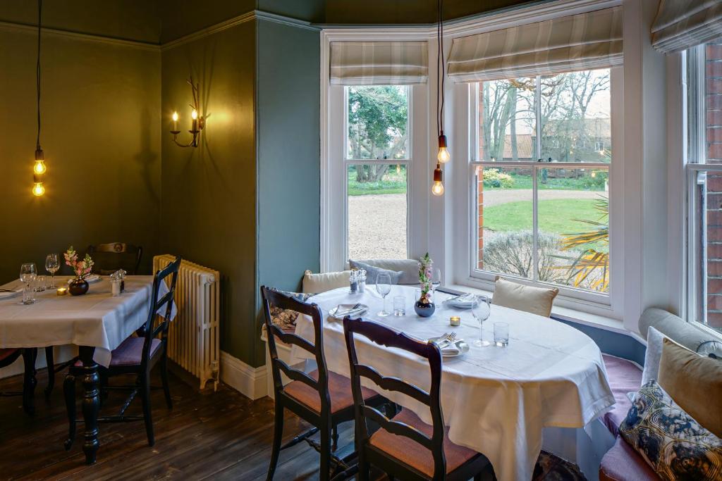 a dining room with two tables and a window at Blakeney House in Blakeney