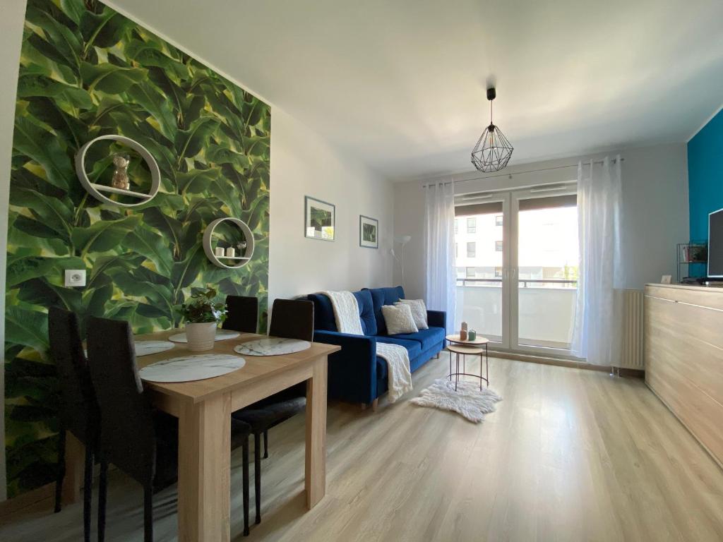 salon ze stołem i niebieską kanapą w obiekcie Platinium Spectrum Apartment w Gdańsku