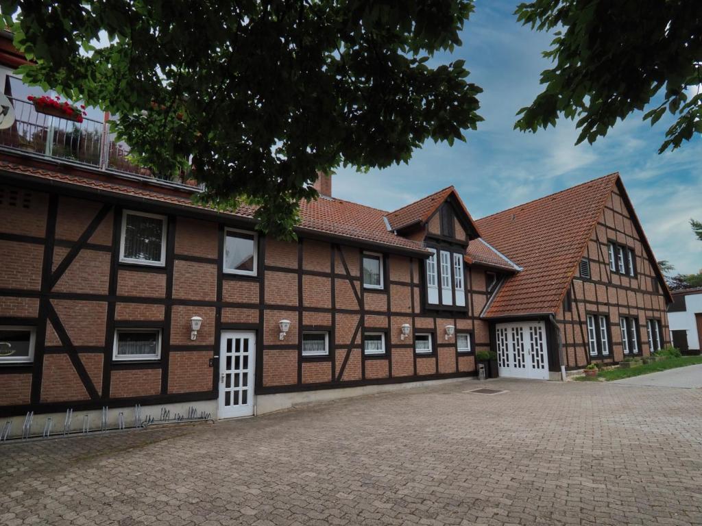 een oud gebouw met witte deuren en bruine baksteen bij Gasthof Erfurth in Sehnde