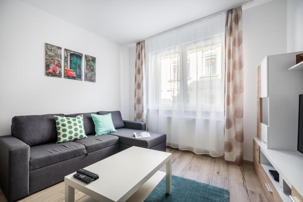 uma sala de estar com um sofá e uma mesa em BpR Brody Street Home em Budapeste