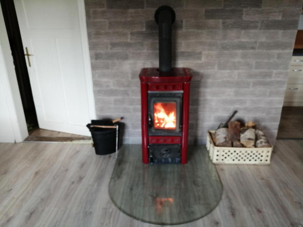 a red stove with a fire in a room at U Petíse in Horní Blatná