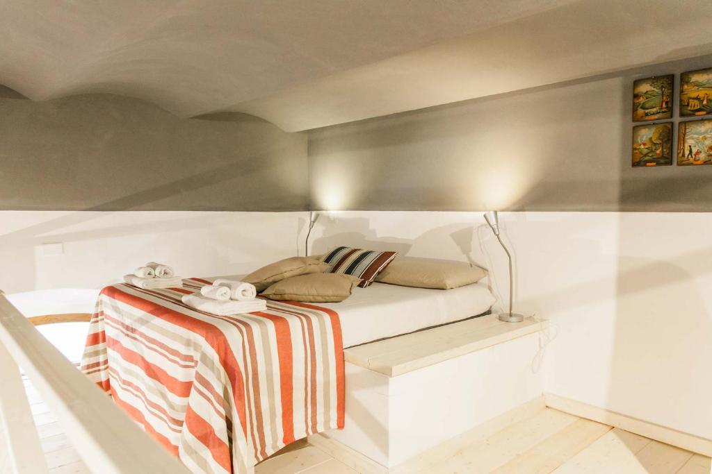 - une petite chambre avec un lit et une couverture rayée dans l'établissement Loft viaveneto, à Volterra