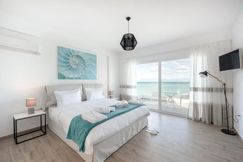 um quarto com uma cama e vista para o oceano em COSTA VASIA Seaside Suites and Apartments em Vrachati