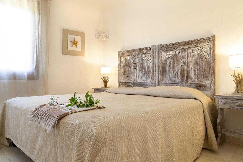 um quarto com uma cama grande e uma cabeceira em madeira em Residence Capraggia em Cannigione