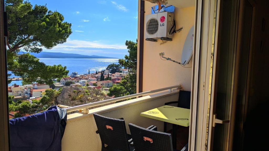 a room with a view of the ocean from a balcony at Apartman Baška Voda in Baška Voda
