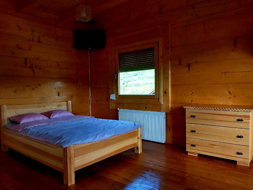 a bedroom with a bed in a log cabin at Domki góralskie na Podhalu Zakopane in Tokarnia