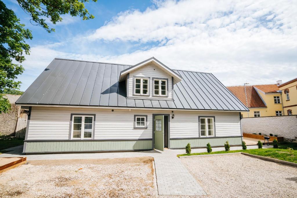 a white house with a grey roof at Wiedemanni 13/1 apartments in Haapsalu