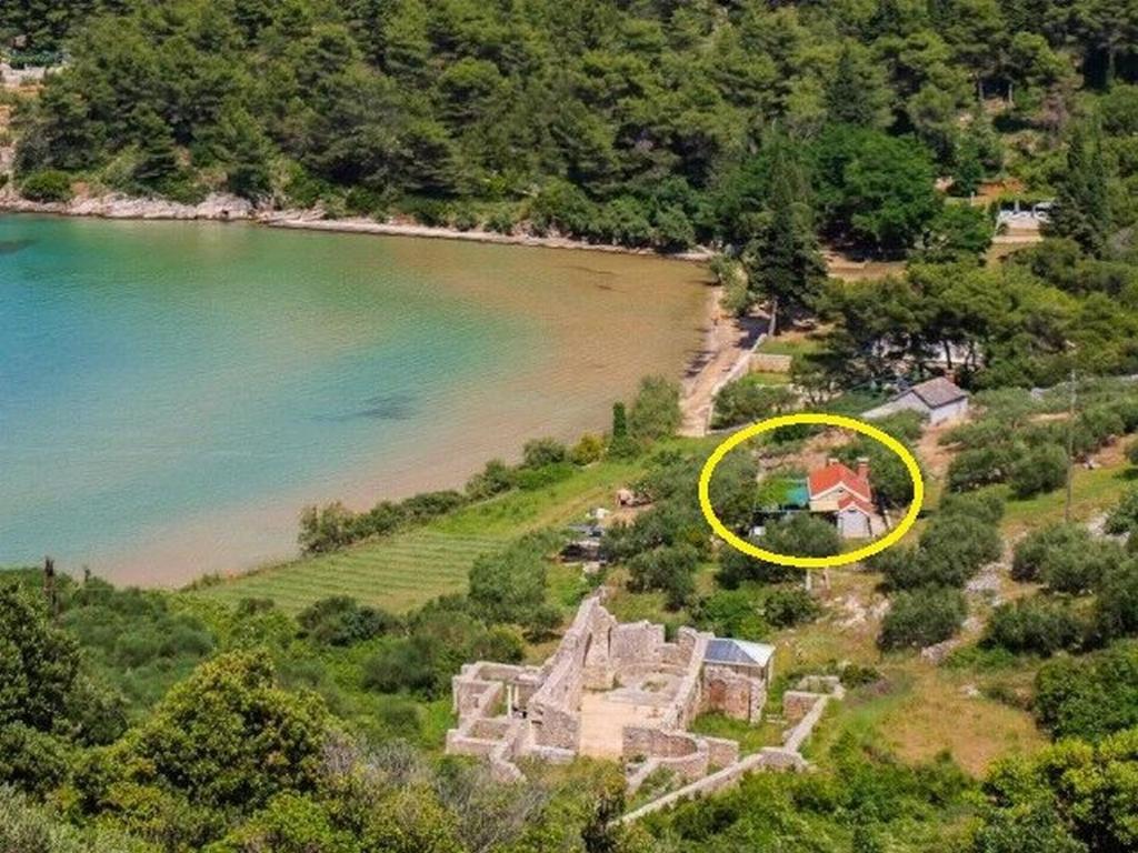 una vista aérea de una casa antigua en una colina junto a un lago en House Ivica, en Postira