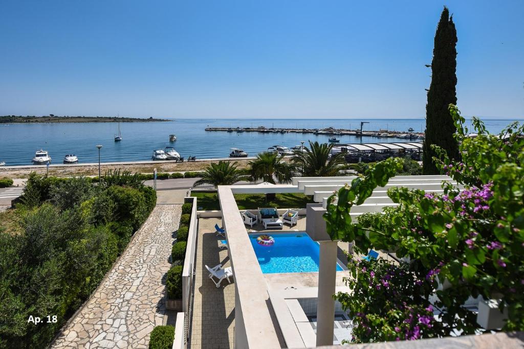 un complejo con piscina y vistas al agua en Apartments Bella Sky en Novalja