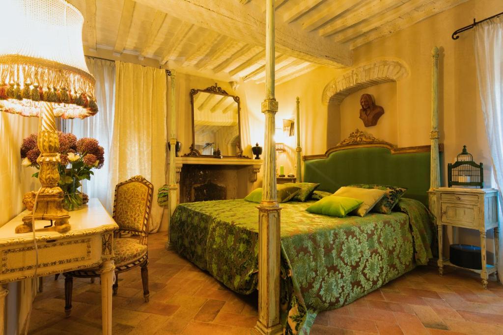 a bedroom with a bed and a table with a lamp at Beccofino in Pienza