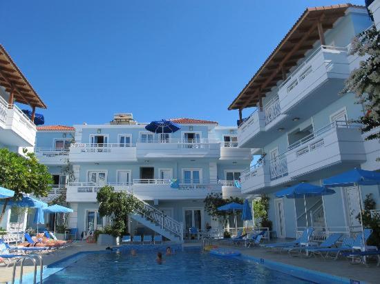 a large white building with a swimming pool in front of it at Mastorakis Village in Agia Marina Nea Kydonias