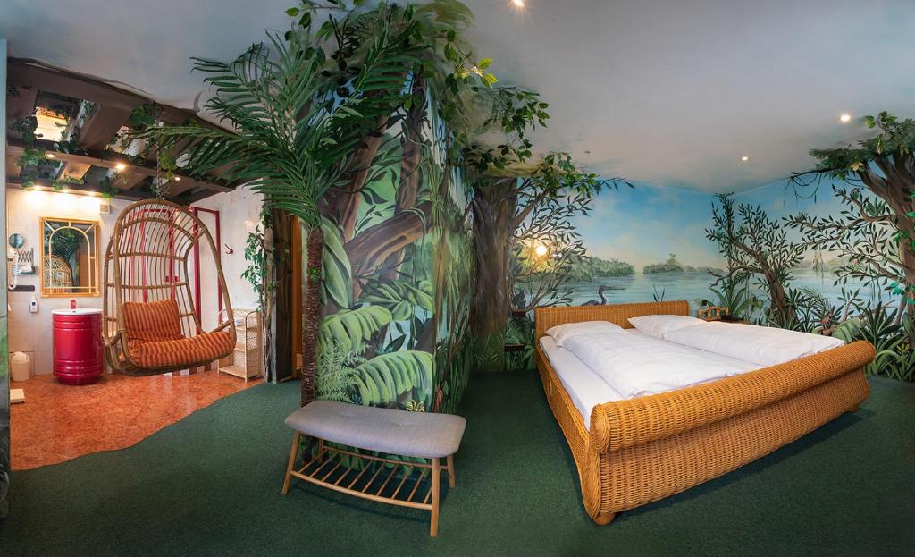 a living room with a couch and a mural of plants at Hotel Plankl in Altötting