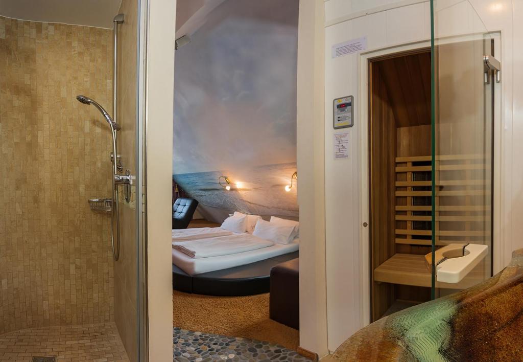 a bathroom with a bedroom with a bed and a shower at Bavaria Lifestyle Hotel in Altötting