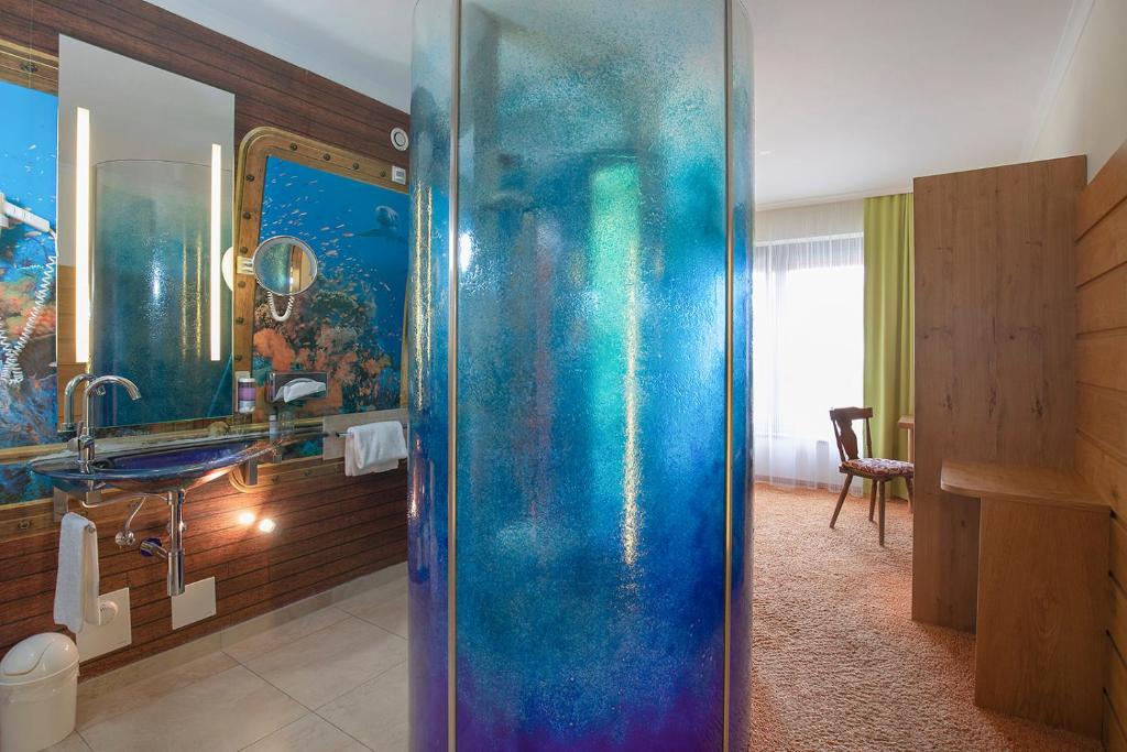 a bathroom with a blue shower in a room at Bavaria Lifestyle Hotel in Altötting
