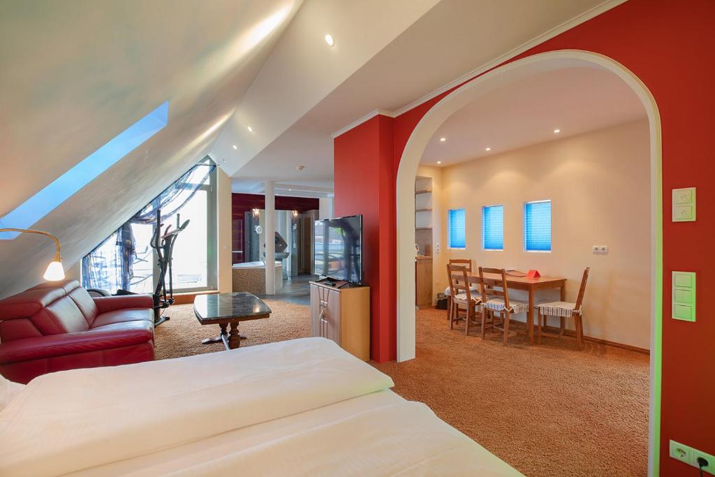 a bedroom with a bed and a living room at Bavaria Lifestyle Hotel in Altötting