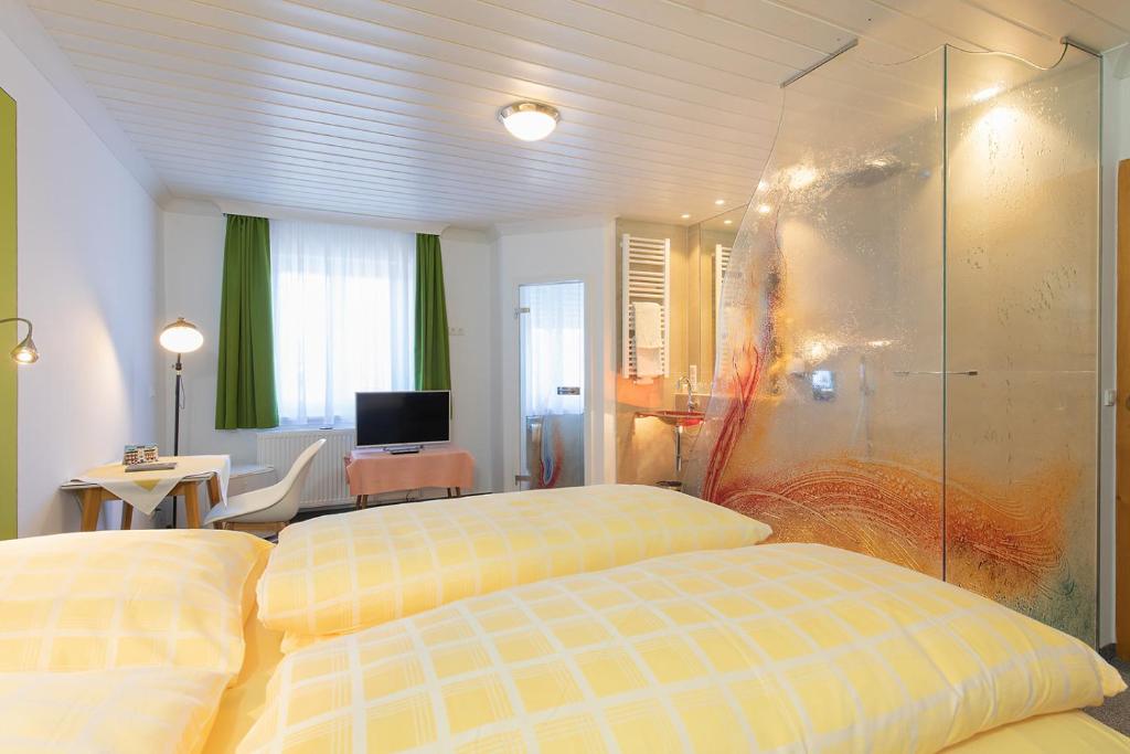 a hotel room with two beds and a television at Altötting City Apartments in Altötting