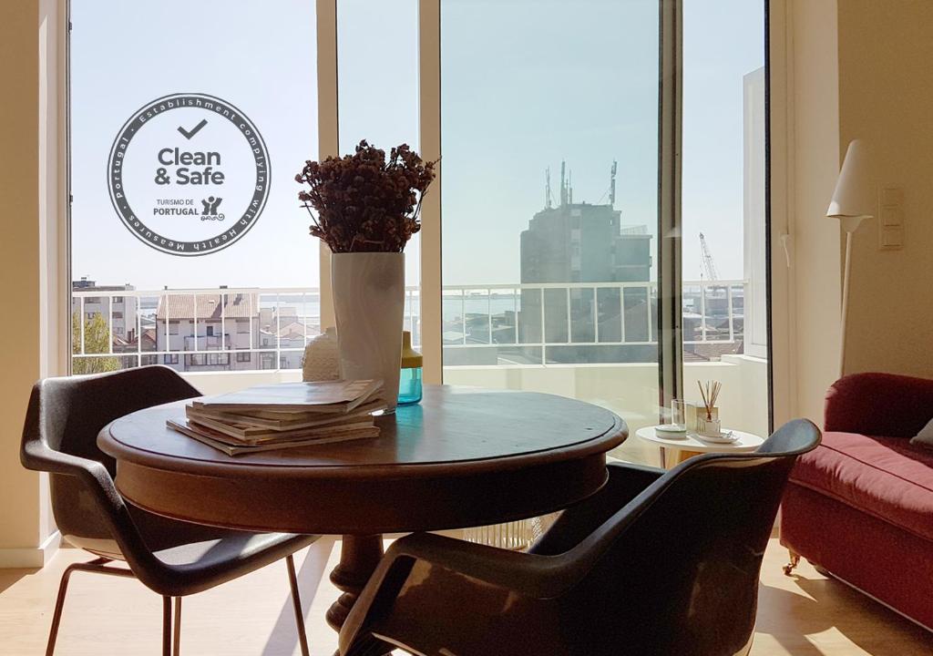 a dining room table with chairs and a vase of flowers at Studio 177 in Matosinhos