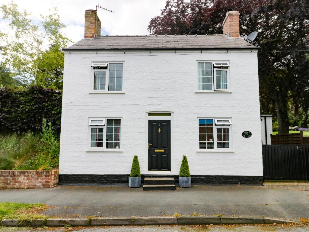 una casa bianca con due alberi davanti di Beech Cottage a Filey