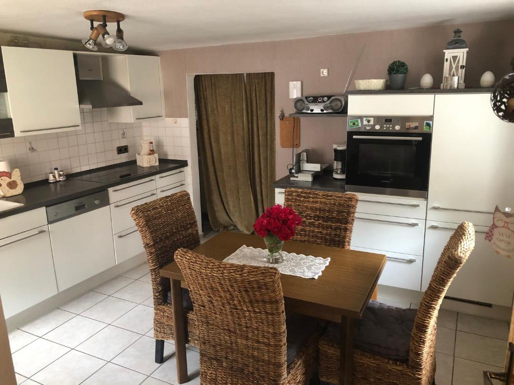 a kitchen with a wooden table and chairs and a kitchen with white cabinets at Ferienhaus in Sankt Aldegund