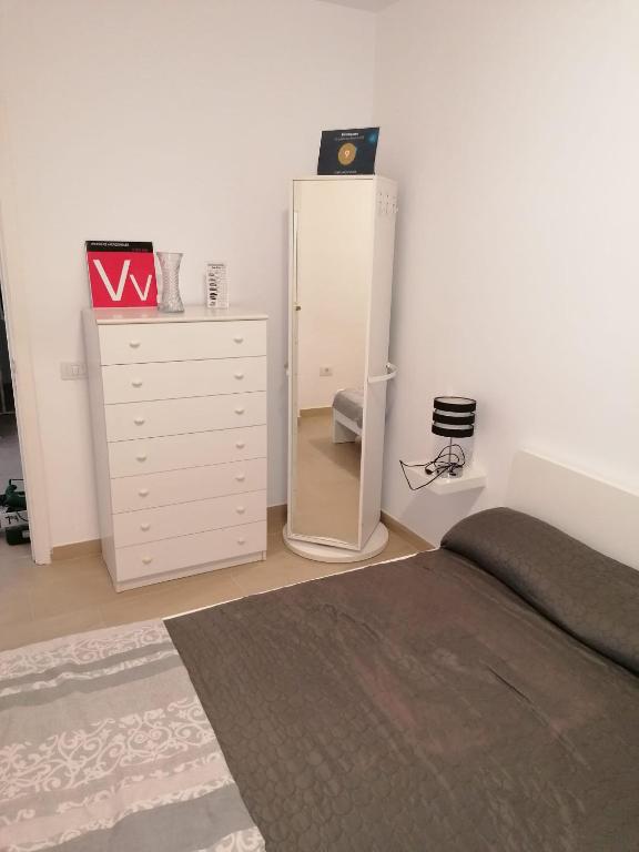 sypialnia z łóżkiem, komodą i lustrem w obiekcie colina apartment w mieście Los Cristianos