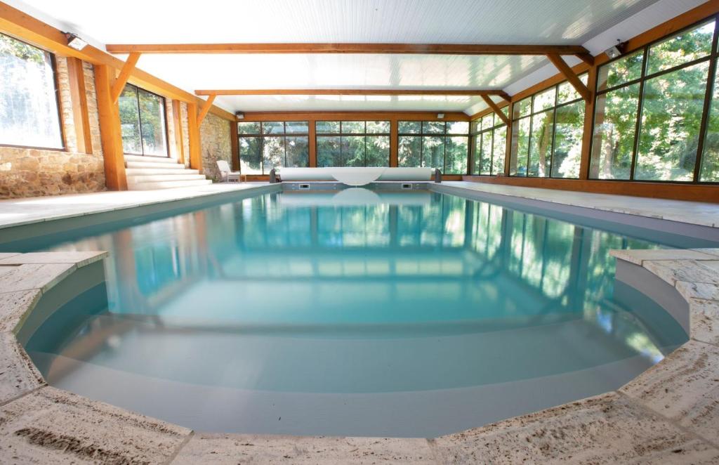 una piscina in una casa con pareti in vetro di Manoir de Penn Lann a Paimpol