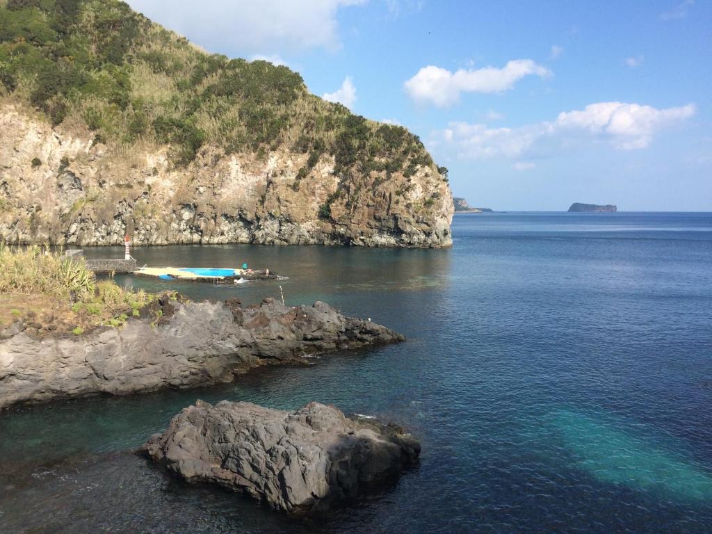 una isla con dos barcos en un cuerpo de agua en Palácio - Exclusive Villa, Caloura, en Água de Pau