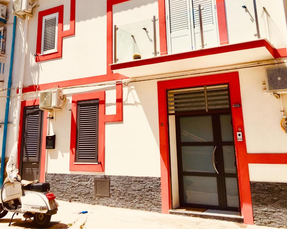 un scooter garé devant un bâtiment avec porte dans l'établissement Casa Escape, à Terrasini
