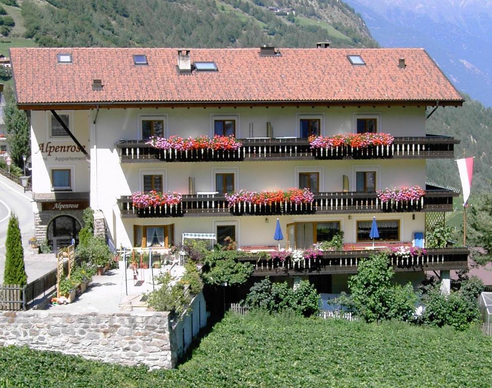 a large building with flowers in the balconies on it at Residence Alpenrose in Martello