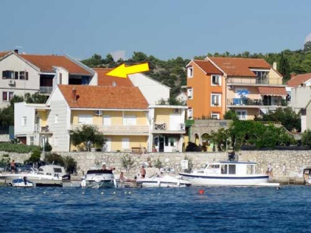 eine Gruppe von Booten in einem Wasserkörper mit Häusern in der Unterkunft Apartments Franciska in Brodarica