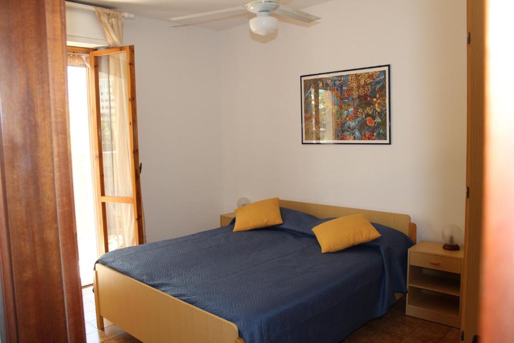 サンタ・マリア・アル・バーニョにあるAppartamento Girasoleのベッドルーム1室(青いシーツと黄色い枕のベッド1台付)