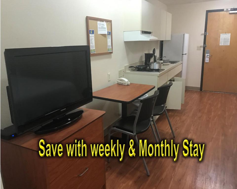 a room with a tv and a table with a kitchen at Best Studio Inn Homestead (Extended Stay) in Homestead