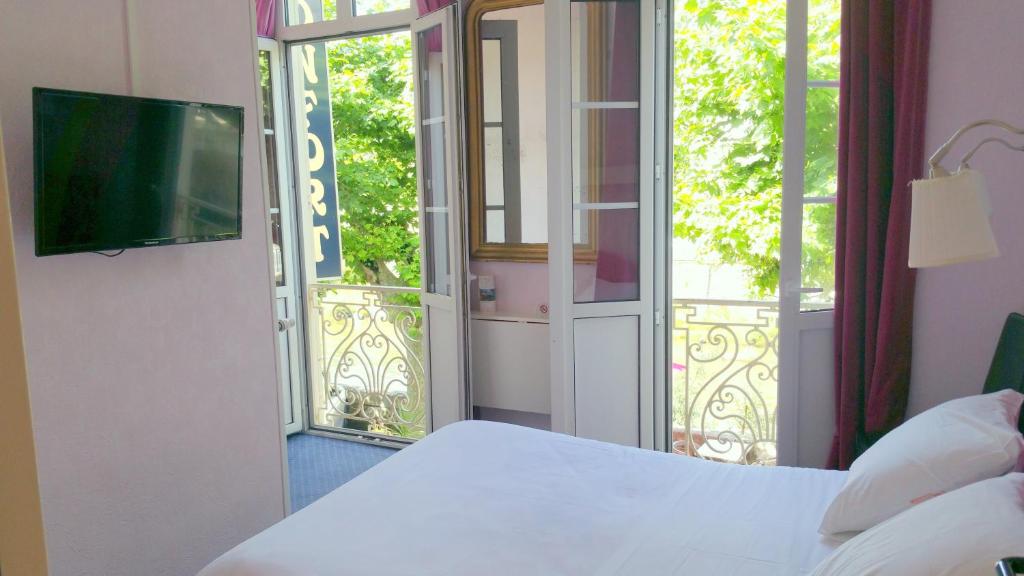 - une chambre avec un lit et une porte coulissante en verre dans l&#39;établissement Hôtel Confort 09 ou HC-09, à Tarascon-sur-Ariège