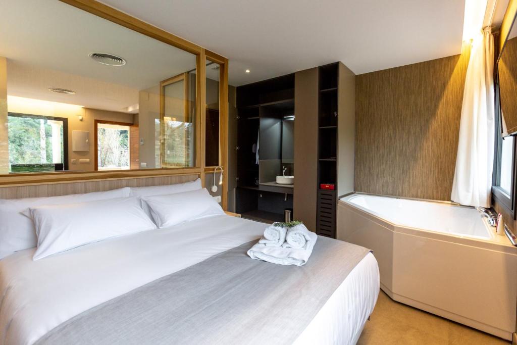 a bedroom with a white bed and a bath tub at Sant Pere Homes in Ballestar