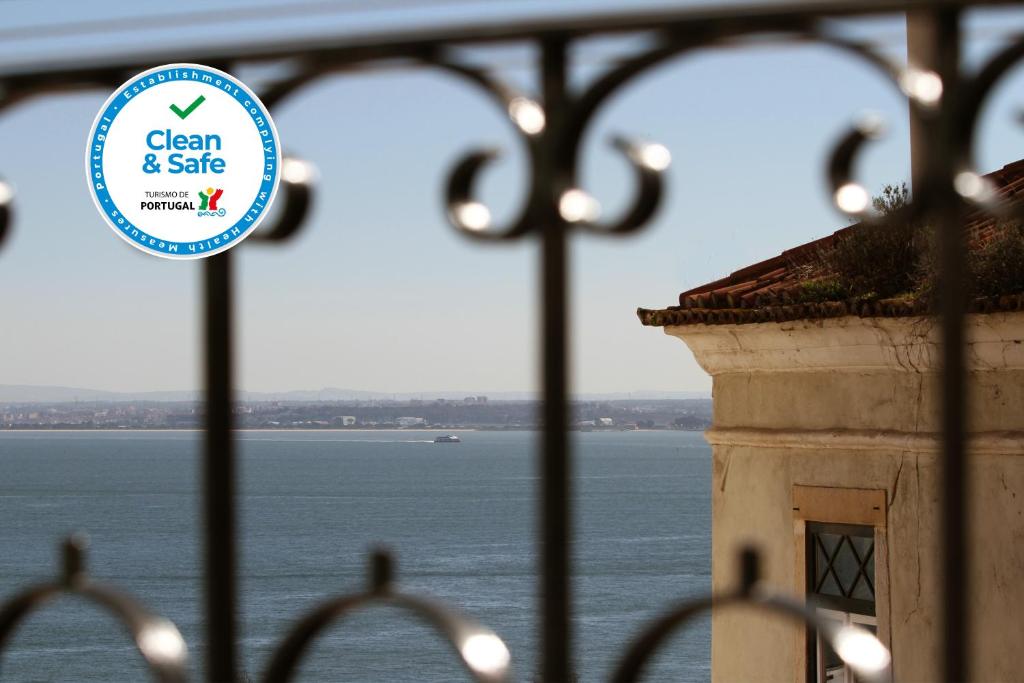 a sign on a gate with a view of the water at Alfama Right Point in Lisbon