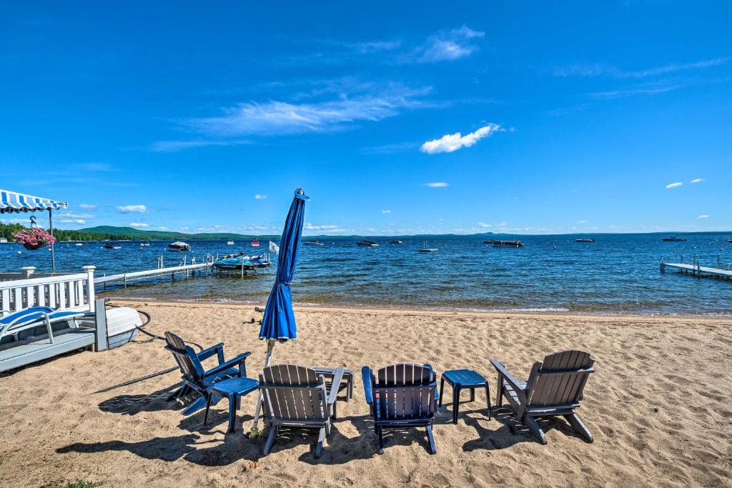 - un groupe de chaises et un parasol sur la plage dans l'établissement Beachfront Sebago Cottage with Deck and Grill!, à North Sebago