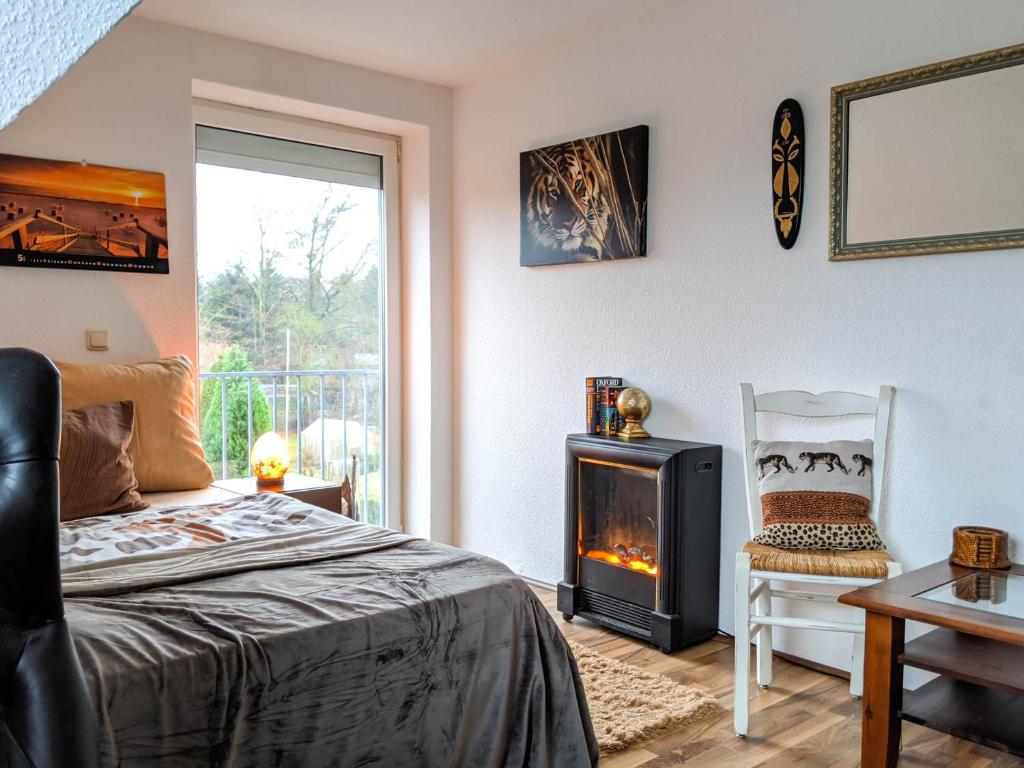 a bedroom with a bed and a fireplace and a chair at Entspanntes Wohnen in Ostseenähe Studio 2 in Ratekau