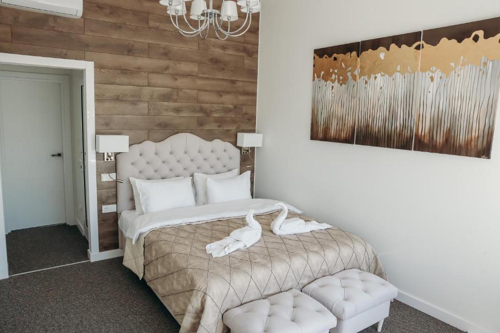 Un dormitorio con una cama blanca y una silla. en 7 Boutique Hotel, en Öskemen