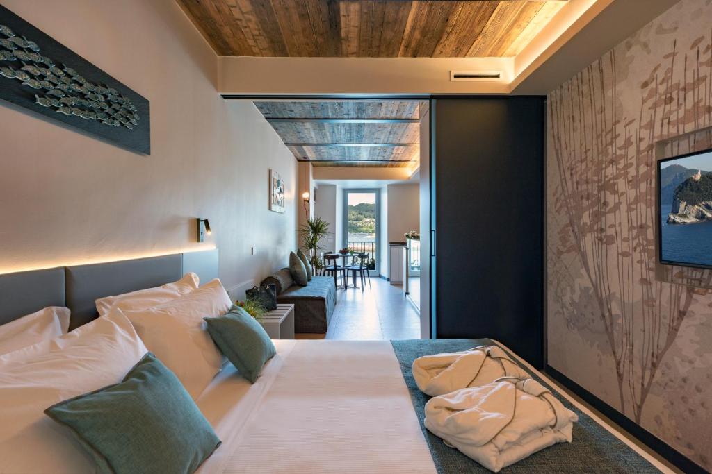 a bedroom with a large bed and a living room at Al Gabbiano "Suite" in Portovenere