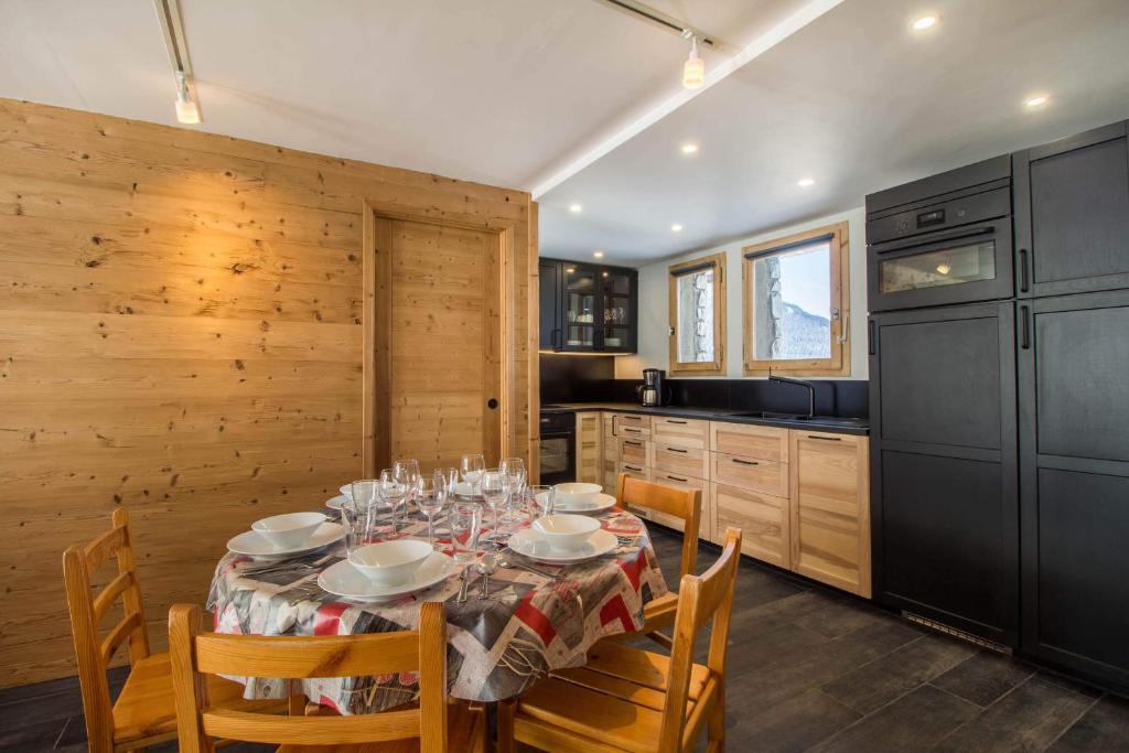 a dining room with a table with chairs and a kitchen at 30 Praz Ski-in Ski-out Vallandry - Les Arcs - Paradiski in Peisey-Nancroix