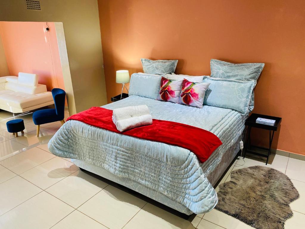 a bedroom with a large bed with colorful pillows at River Valley Guest House in Butterworth