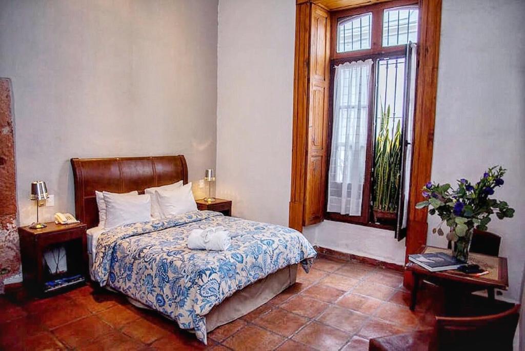 a bedroom with a bed and a window at Casa Aspeytia Hotel Boutique in Querétaro