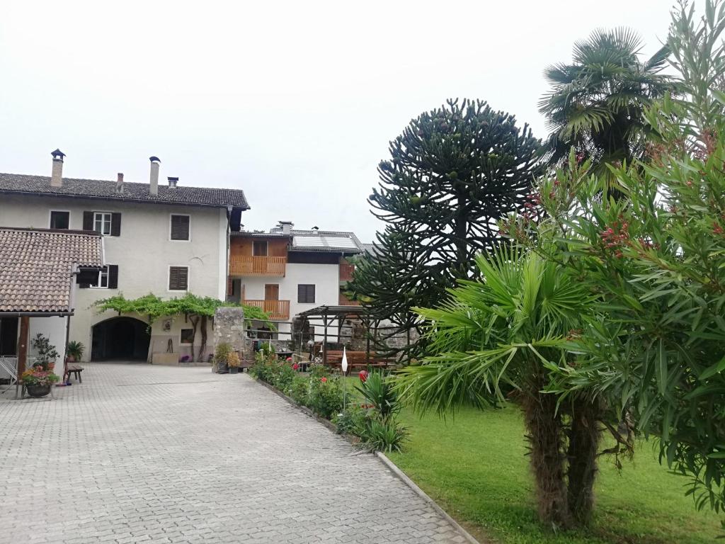 a courtyard of a house with trees and a building at Beim Sarner in Caldaro