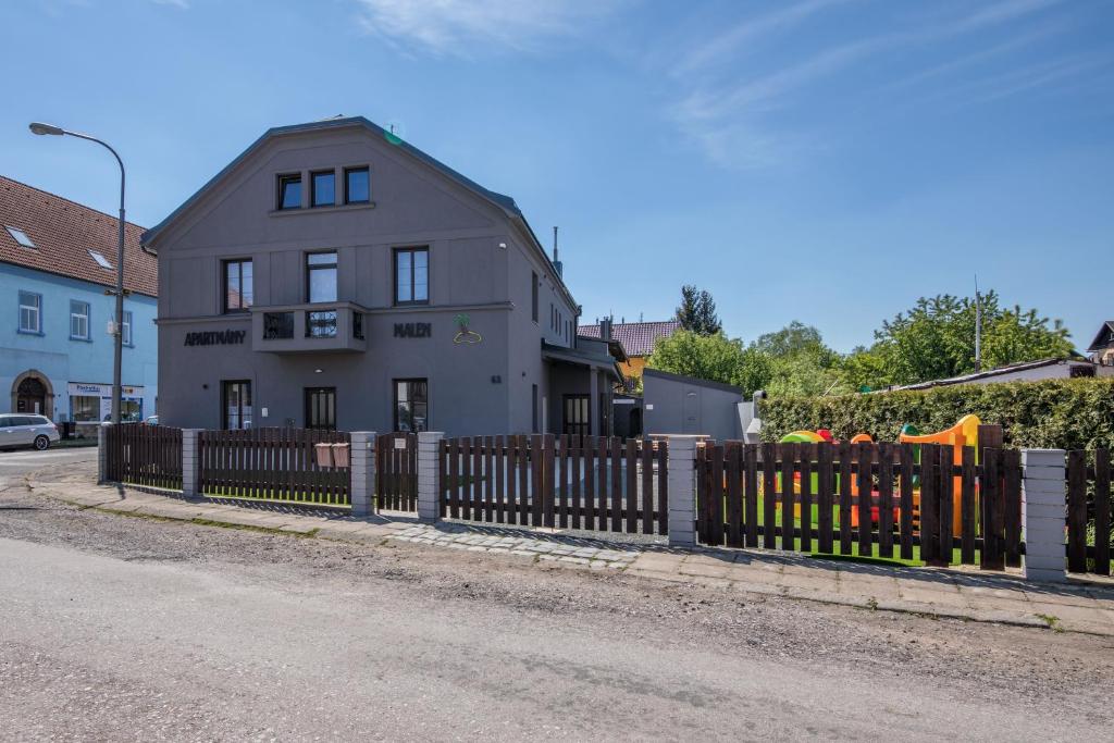 a house with a wooden fence in front of a house at Apartmány Malen in Dvůr Králové nad Labem
