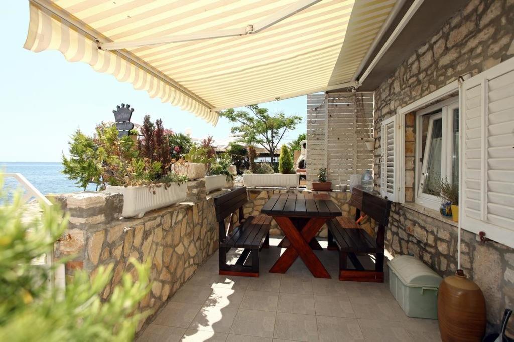a patio with a table and a stone wall at Sea view apartment Umag 2 in Umag