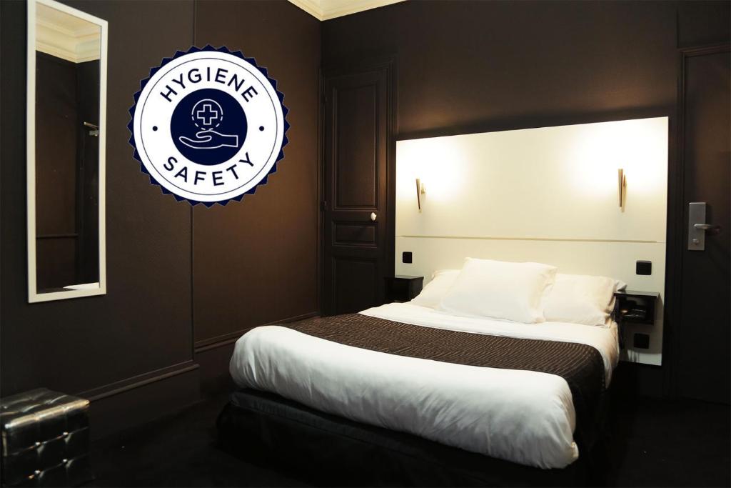 a bedroom with a bed with a sign on the wall at Hôtel de l'Exposition - République in Paris
