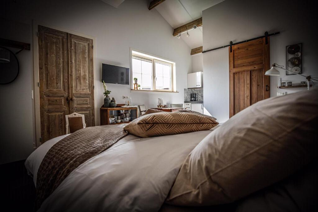 ein Schlafzimmer mit einem großen Bett und einem Fenster in der Unterkunft B&B Zen in Lage Zwaluwe