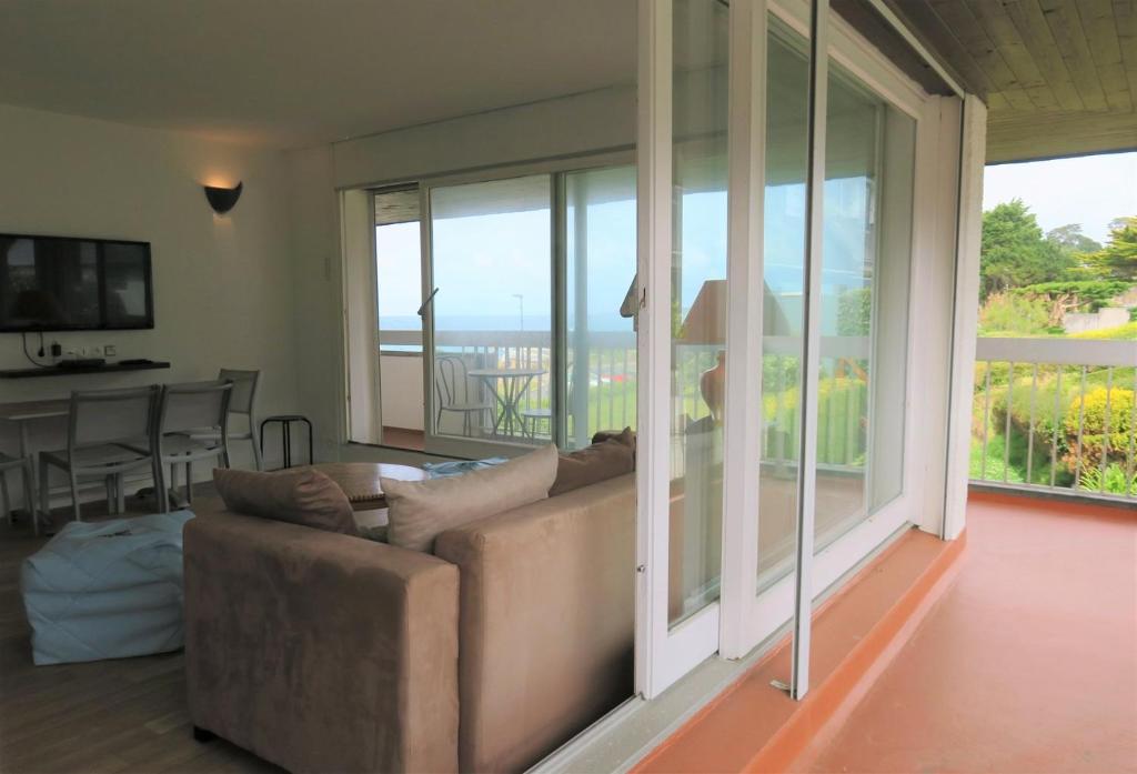 un salon avec un canapé et une grande fenêtre dans l'établissement Appartement VUE SUR MER avec terrasse, plage de Trestraou à PERROS-GUIREC - Ref 861, à Perros-Guirec