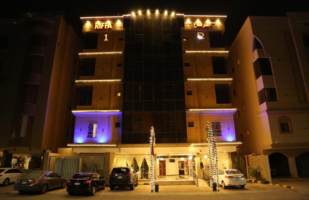 un edificio con coches aparcados delante de él por la noche en سمأ الرفاع 1, en Al Khobar